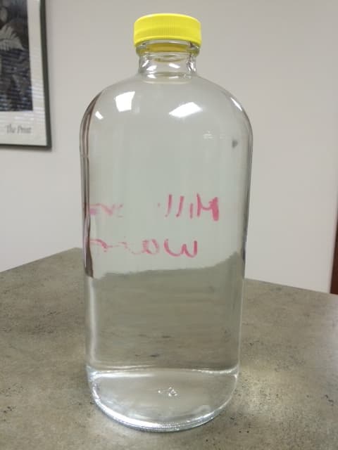 Clear drinking water sample in a glass bottle