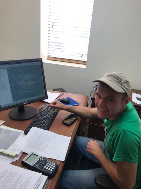 Environmental engineering intern Andrew Bannit working at a computer